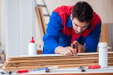 Yooung marangoz boyayla uğraşıyor.