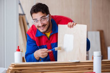 Yooung marangoz boyayla uğraşıyor.