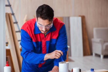 Yooung marangoz boyayla uğraşıyor.