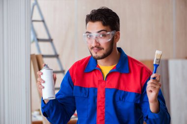 Yooung marangoz boyayla uğraşıyor.