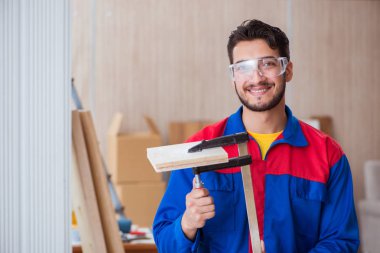 Klemplerle çalışan genç bir tamirci.