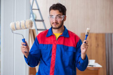 Yooung marangoz boyayla uğraşıyor.