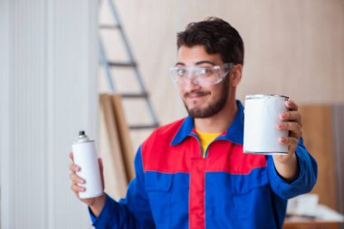 Yooung marangoz boyayla uğraşıyor.