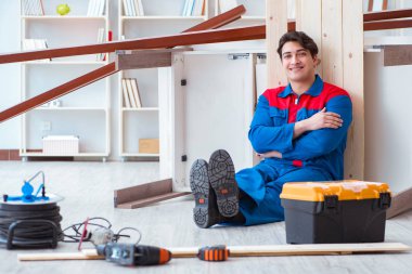 Genç marangoz ahşap kalaslarla çalışmaya ara veriyor.