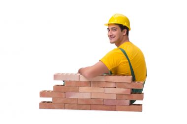 Yakışıklı inşaat işçisi tuğla duvar inşa ediyor.