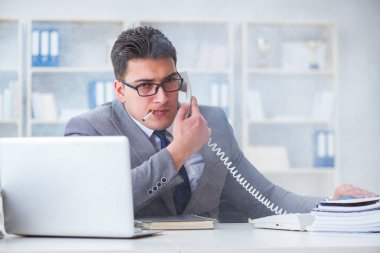 İşadamı ofisinde sigara içiyor.