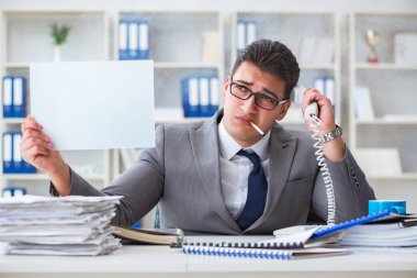 Ofiste sigara içen bir iş adamı elinde boş bir mesaj tutuyor.