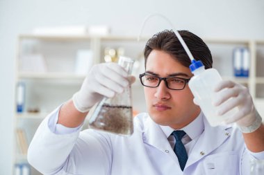 Genç araştırmacı bilim adamı bir su testi kirliliği araştırması yapıyor.