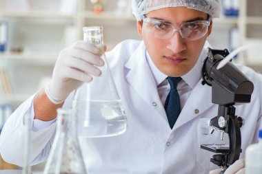 Genç araştırmacı bilim adamı bir su testi kirliliği araştırması yapıyor.