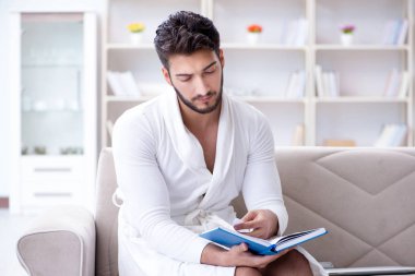 Öğrenci işadamı genç adam bir kitap okuyor.