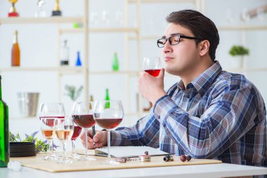 Profesyonel şarap garsonu kırmızı şarap tadıyor.