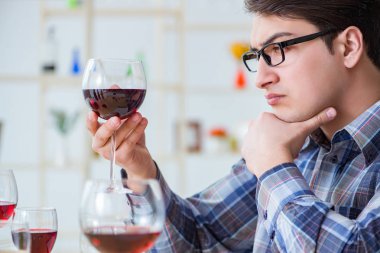 Profesyonel şarap garsonu kırmızı şarap tadıyor.