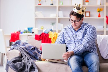 Genç adam dağınık bir odada çalışıyor.