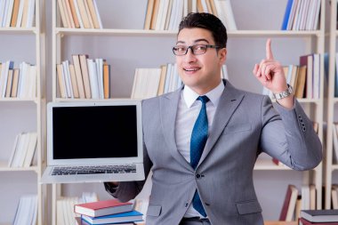 Kütüphanede çalışan boş ekran bilgisayarı olan bir iş adamı.