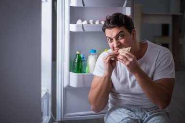 Buzdolabındaki adam gece yemek yiyor.