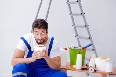 Tamirci, duvar kağıdıyla evde tadilat yapıyor.