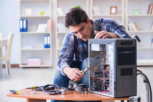 Hombre discapacitado en silla de ruedas reparación de computadoras —  Fotos de Stock