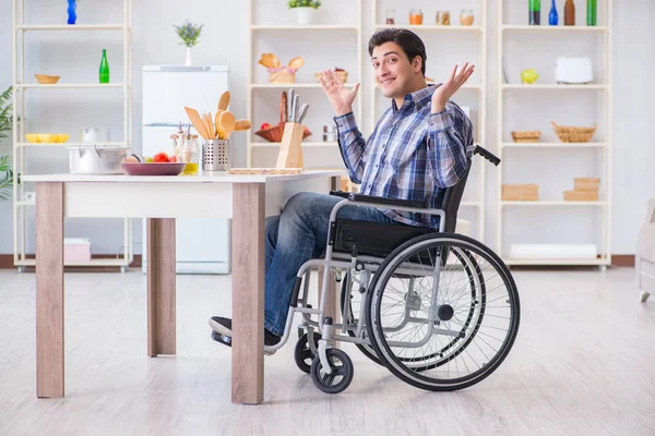 Engelli genç koca mutfakta çalışıyor.