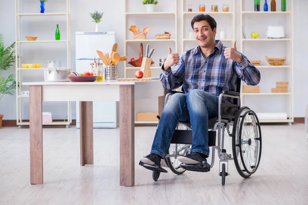 Engelli genç koca mutfakta çalışıyor.