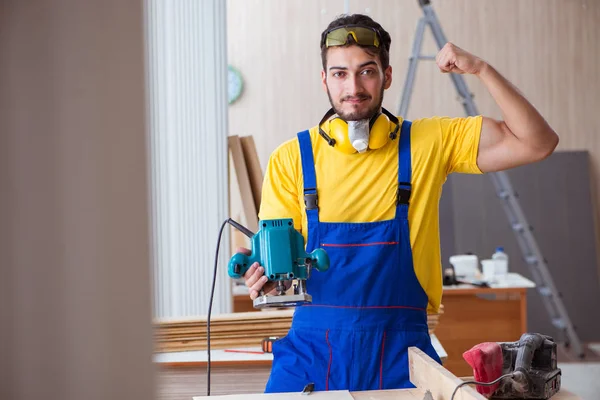 Junger Schreiner, der mit Elektrowerkzeugen arbeitet — Stockfoto