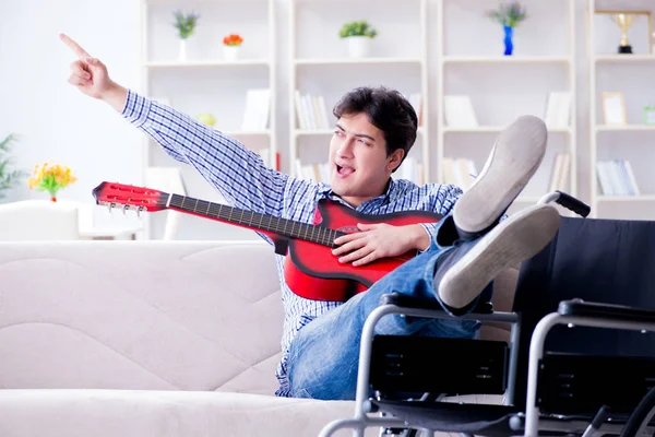 Homem com deficiência tocando guitarra em casa — Fotografia de Stock