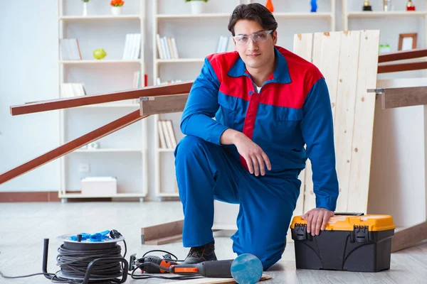 Genç marangoz ahşap kalaslarla çalışıyor.