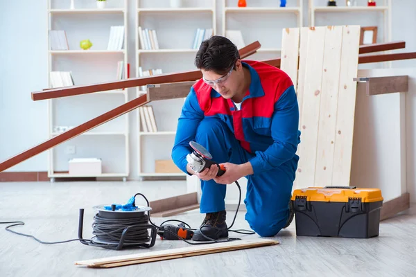 Genç marangoz ahşap kalaslarla çalışıyor.