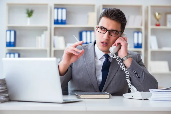 Geschäftsmann raucht im Büro bei der Arbeit — Stockfoto