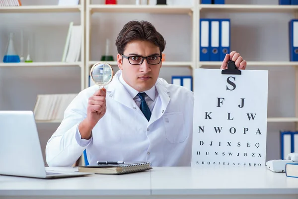 Médico óptico con carta gráfica llevando a cabo una comprobación de la prueba ocular —  Fotos de Stock