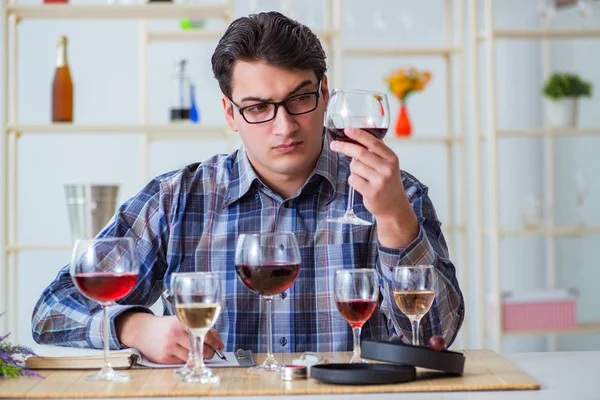 Profesyonel şarap garsonu kırmızı şarap tadıyor.