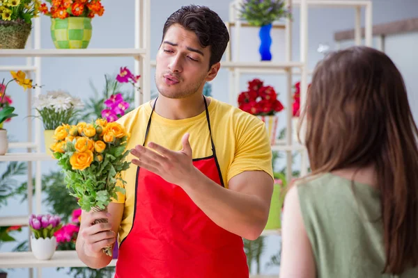 Florista vendendo flores em uma loja de flores — Fotografia de Stock