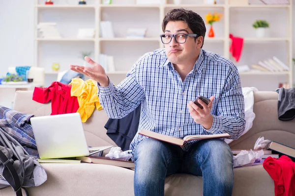 Genç adam dağınık bir odada çalışıyor.