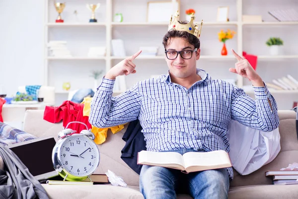 Genç adam dağınık bir odada çalışıyor.