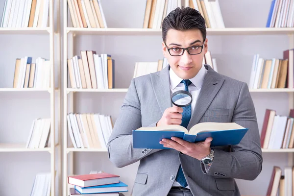 Студент бізнес-права зі збільшувальним склом читає книгу — стокове фото