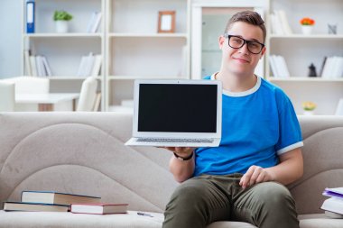 Sınavlara hazırlanan genç öğrenci kanepede ders çalışıyor.