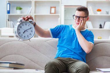 Sınavlara hazırlanan genç öğrenci kanepede ders çalışıyor.