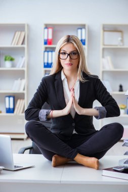 İş kadını ofiste meditasyon yaparken hayal kırıklığına uğradı