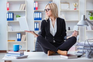 İş kadını ofiste meditasyon yaparken hayal kırıklığına uğradı