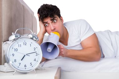 Yatakta uykusuzluk çeken bir adam.