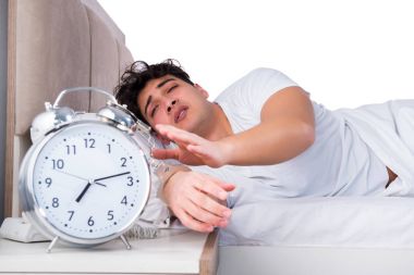 Yatakta uykusuzluk çeken bir adam.