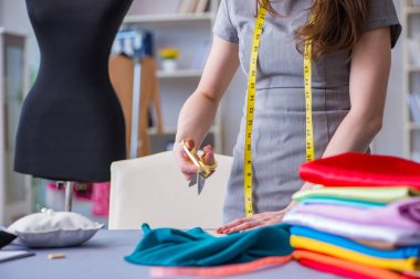 Kadın terzi dikiş dikmek için dikiş dikiyor.