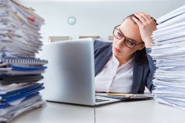Evrak işleriyle uğraşan yorgun bir iş kadını.