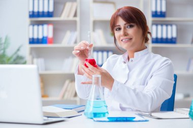 Bir laboratuarda deney yapan kadın bir bilim adamı.