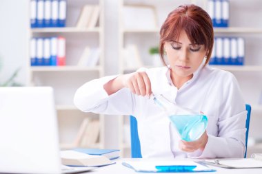 Bir laboratuarda deney yapan kadın bir bilim adamı.