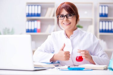 Bir laboratuarda deney yapan kadın bir bilim adamı.