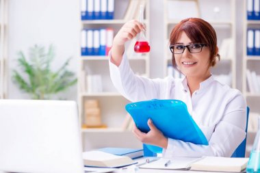 Bir laboratuarda deney yapan kadın bir bilim adamı.