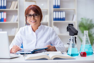 Bir laboratuarda deney yapan kadın bir bilim adamı.