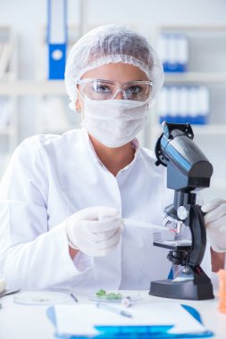 Bir laboratuarda deney yapan kadın bir bilim adamı.