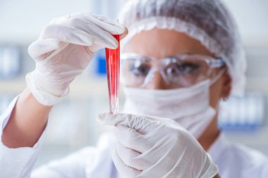 Bir laboratuarda deney yapan kadın bir bilim adamı.