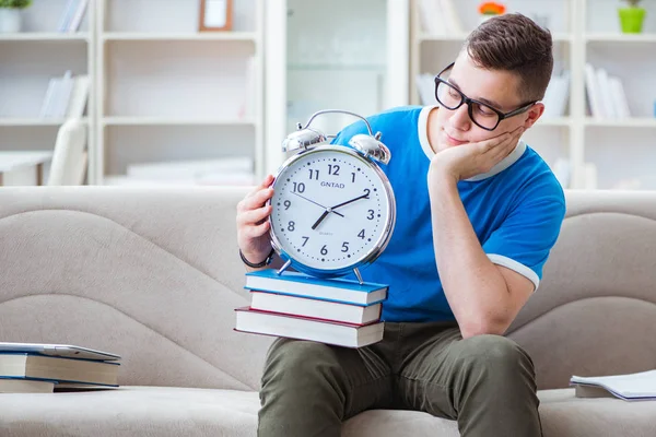 Sınavlara hazırlanan genç öğrenci kanepede ders çalışıyor.